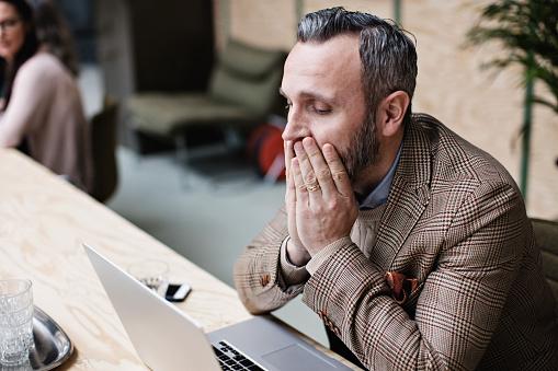 man with hands over mouth