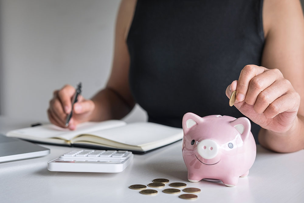 woman putting coin into bank