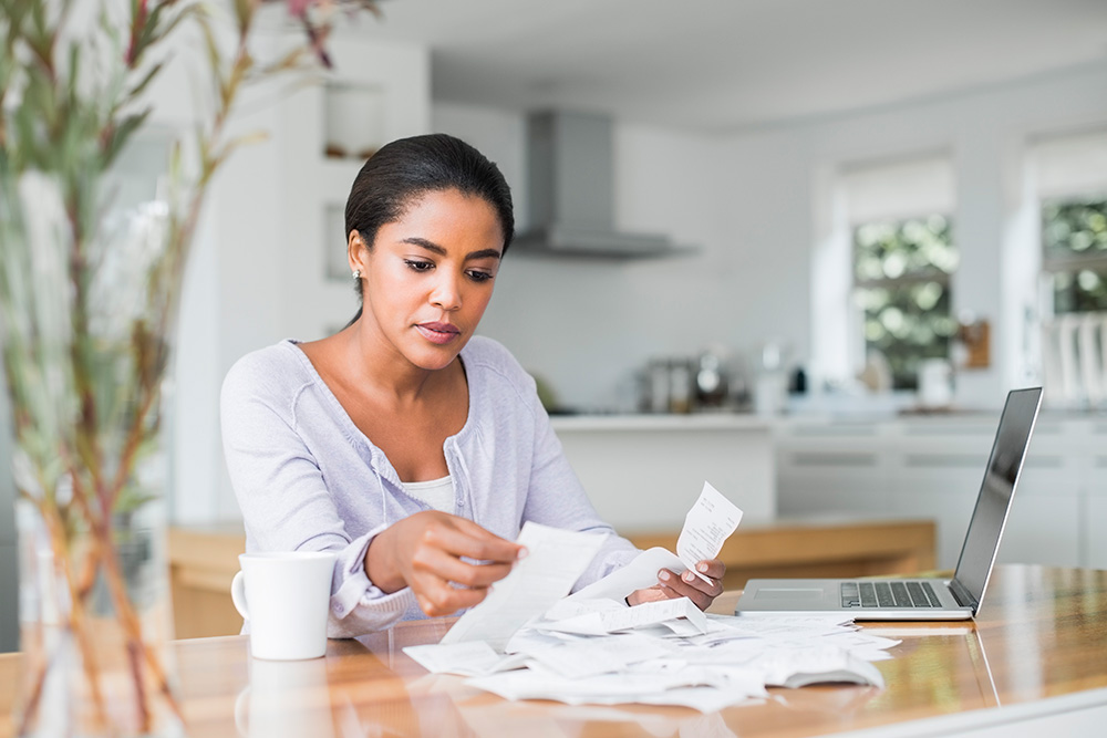 woman with receipts at computer